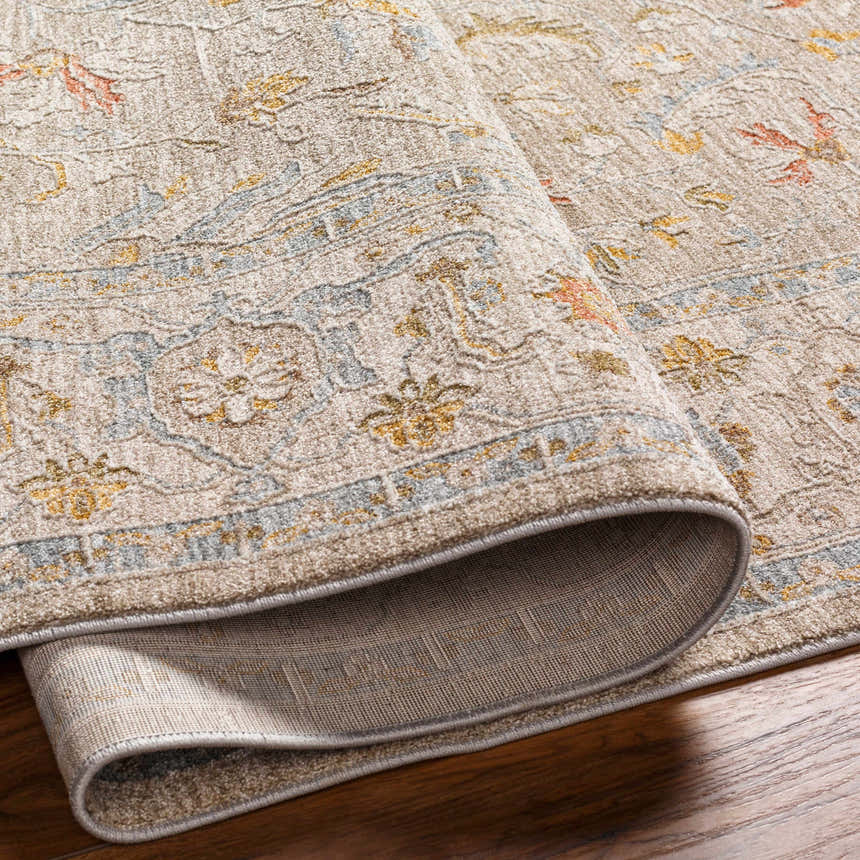 Close-up of the Awena Thick Luxe Area Rug showing its amber, dusty pink, and gray traditional pattern and plush texture. Fold