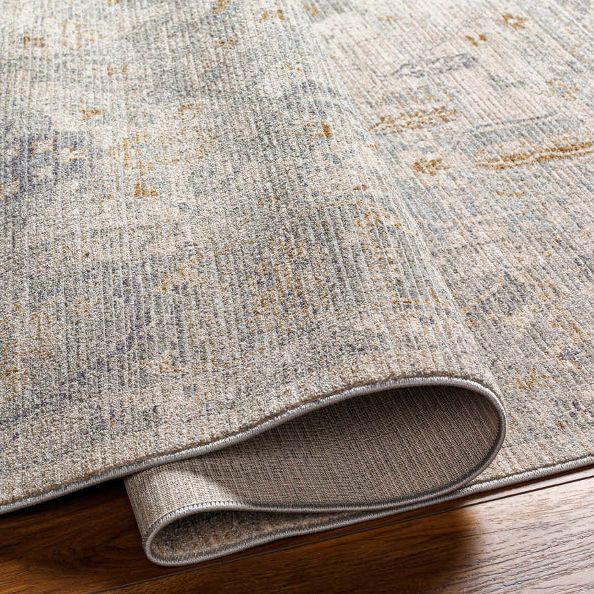 Close up of Ayarn Thick Luxe Statement Rug showing brown, gray, and teal tones and soft, textured pile. Fold