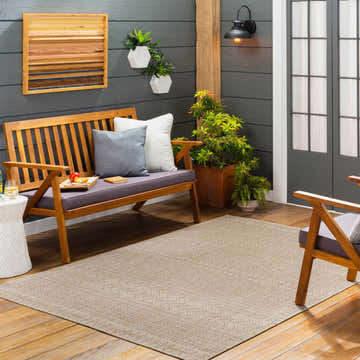Outdoor patio scene with a Madras Cream All Over Performance Rug, wood bench, gray accent wall, and potted plants. Roomscene-Rectangle