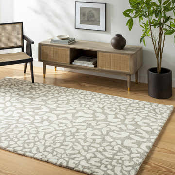 Living room scene with beige Azuka Leopard Print Area Rug, wood floors, console table, chair, and potted plant. Roomscene-Rectangle
