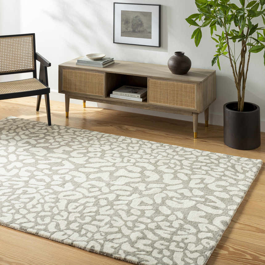 Living room scene with beige Azuka Leopard Print Area Rug, wood floors, console table, chair, and potted plant. Roomscene-Rectangle