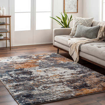 Living room scene with a Babatngon Rock Pattern Luxe Rug in blue, brown, and cream under a beige sofa. Roomscene-Rectangle