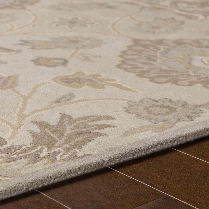Close-up of the Conesus 1192 rug. Hand-tufted wool rug in ivory and taupe with a floral pattern on a hardwood floor. Texture