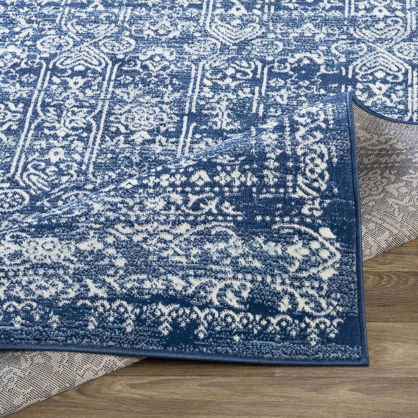 Close-up of the Michie Dark Blue Area Rug showing its detailed white and blue Bohemian-style pattern and texture. Fold