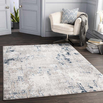 Living room scene with a cream chair and blue Balranald Area Rug on dark wood floors. Neutral, contemporary style. Roomscene-Rectangle