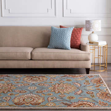 Living room scene with a Conesus Hand Tufted Gray 1052 Area Rug, beige sofa, and gold side table with a lamp. Roomscene-Rectangle