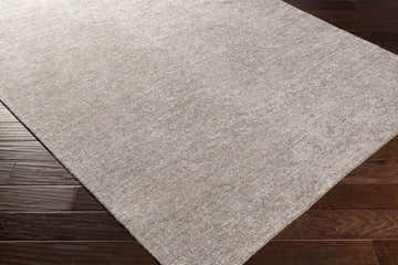 Close-up of the hand woven Barstow Gray Viscose Rug showing texture and color on dark wood floors. Corner