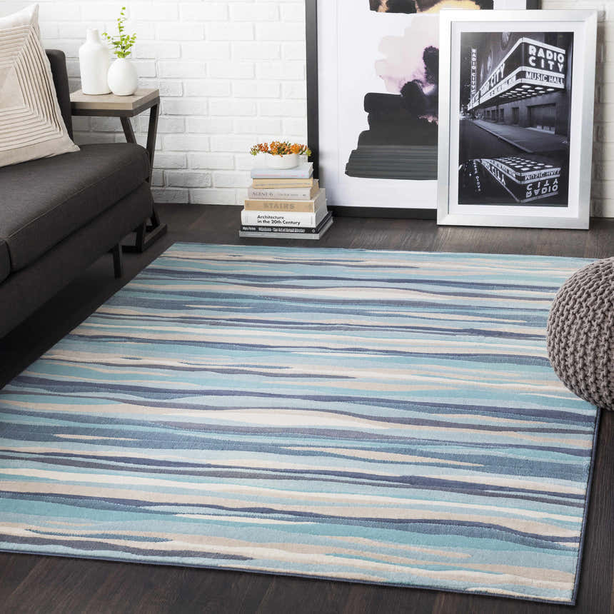 Living room scene with blue striped Basco Area Rug, gray sofa, and modern decor. Roomscene-Rectangle