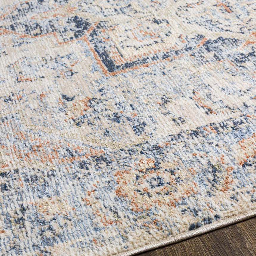 Close-up of Bayog Area Rug showing its brick red, cream, denim, and gray traditional pattern and soft polyester texture. Texture