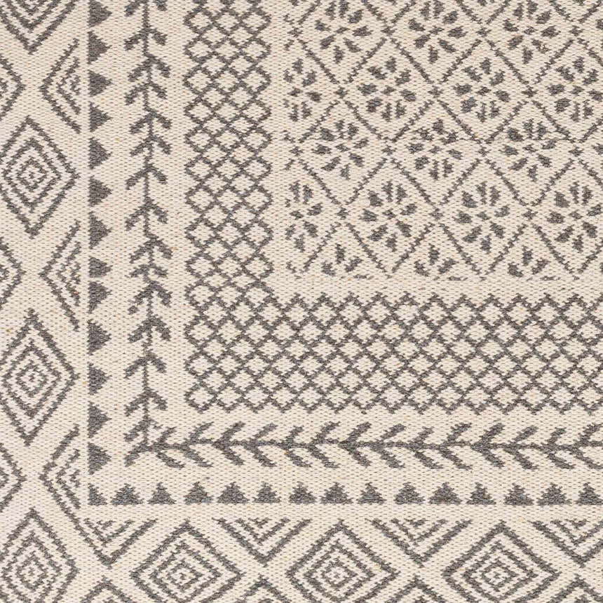Close-up of the hand woven Bayou Area Rug. Beige wool rug with gray diamond, floral, and geometric patterns. Swatch