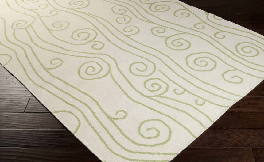 Close-up of the ivory Beggs Area Rug with a light green swirl and line pattern. Hand woven wool rug. Corner