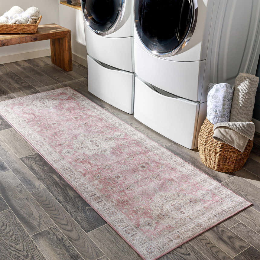 Laundry room scene with Bergman Distressed Red Area Rug, white stacked washer/dryer, wood bench, and basket of towels. Roomscene-Runner