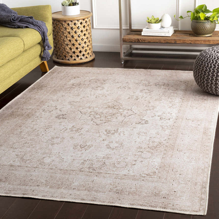 Living room scene with a beige Bethany Vintage Flat Pile Washable Rug, green sofa, and bohemian decor. Roomscene-Rectangle