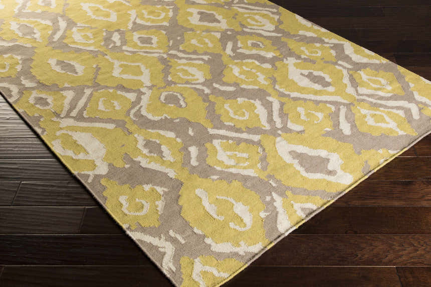 Close-up of the Bighorn Area Rug showing its light beige, tan, and yellow bohemian pattern and hand-woven texture. Corner