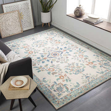 Living room scene with a Bilsdale area rug in cream, blue, burnt orange, and green. Bohemian style with a traditional floral pattern. Roomscene-Rectangle