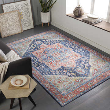 Living room scene with a blue, red, and beige Blaze Area Rug, gray sofa, and side table. Bohemian style. Roomscene-Rectangle