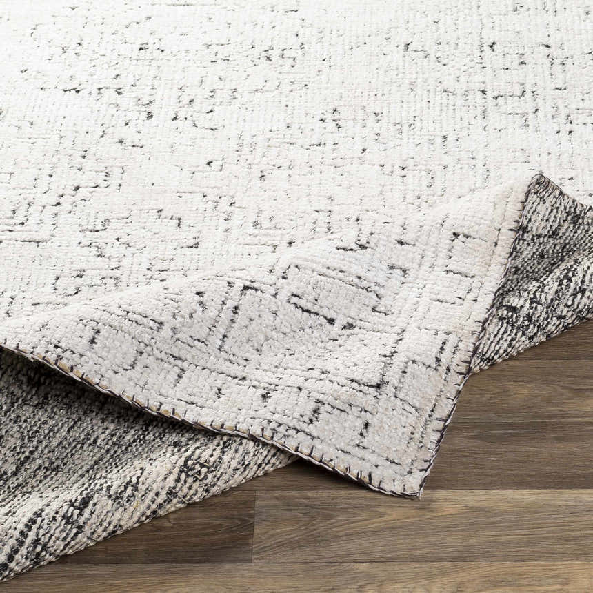 Close-up of the Blackfoot Area Rug showing the hand-knotted construction and black and white farmhouse design. Fold