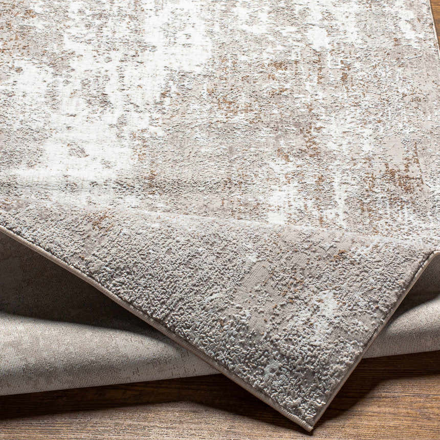 Close-up of the Binabaan Abstract Area Rug featuring a textured charcoal, ivory, and tan abstract design. Fold