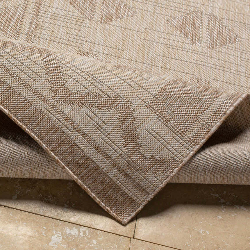 Close-up of the Mangoso Beige Area Rug showing its woven texture and geometric pattern in off-white, tan, and taupe. Fold