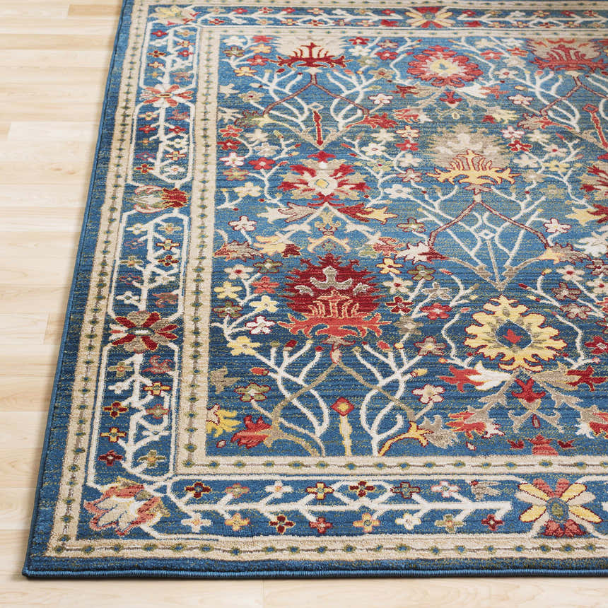 Close-up of the Neola Navy Blue Damask Area Rug. Features a traditional floral pattern in red, yellow, and white on a blue background. Front