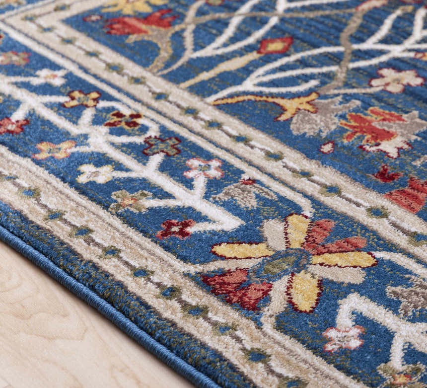 Close-up of the Neola Navy Blue Damask Area Rug. Features a traditional floral pattern with red, yellow, and tan on a blue background. Pile