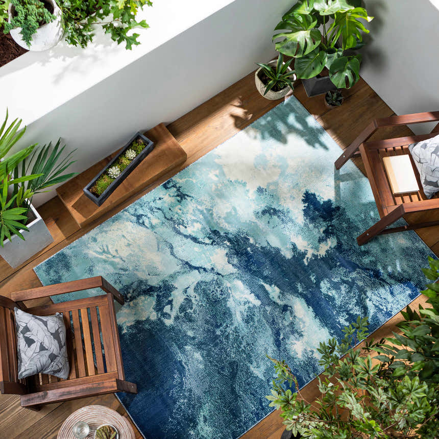 Bright Sky Indoor/Outdoor Rug styled on a wood deck with chairs and plants. Coastal style in navy, pale blue, ivory. Roomscene-Rectangle