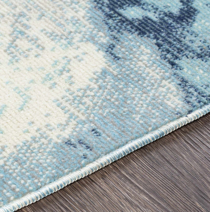 Close-up of Bright Sky Indoor/Outdoor Rug showing ivory, light slate, navy, and pale blue abstract pattern and woven texture. Texture