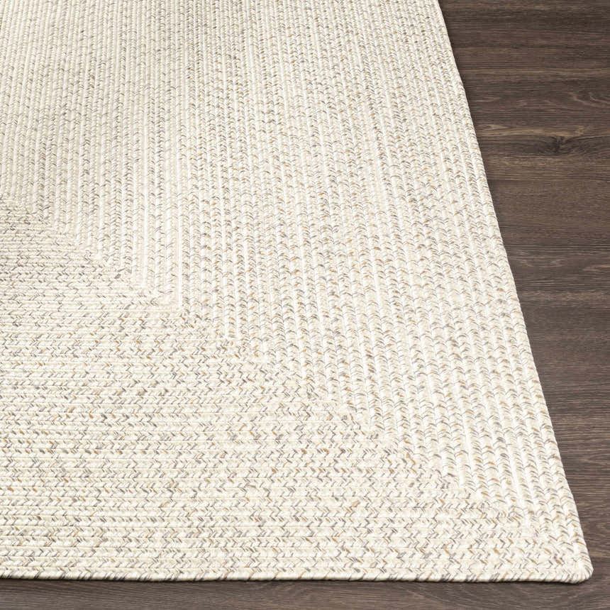 Close-up of Beige Braided Faux Jute Rug showing the braided texture and neutral colors on a dark wood floor. Front