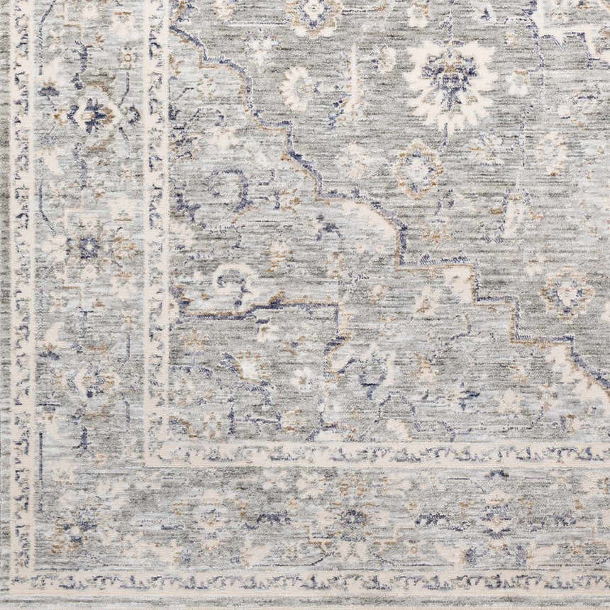 Close up of Brodhead Luxe Area Rug showing a traditional, faded floral pattern in cream, taupe, and denim. Swatch