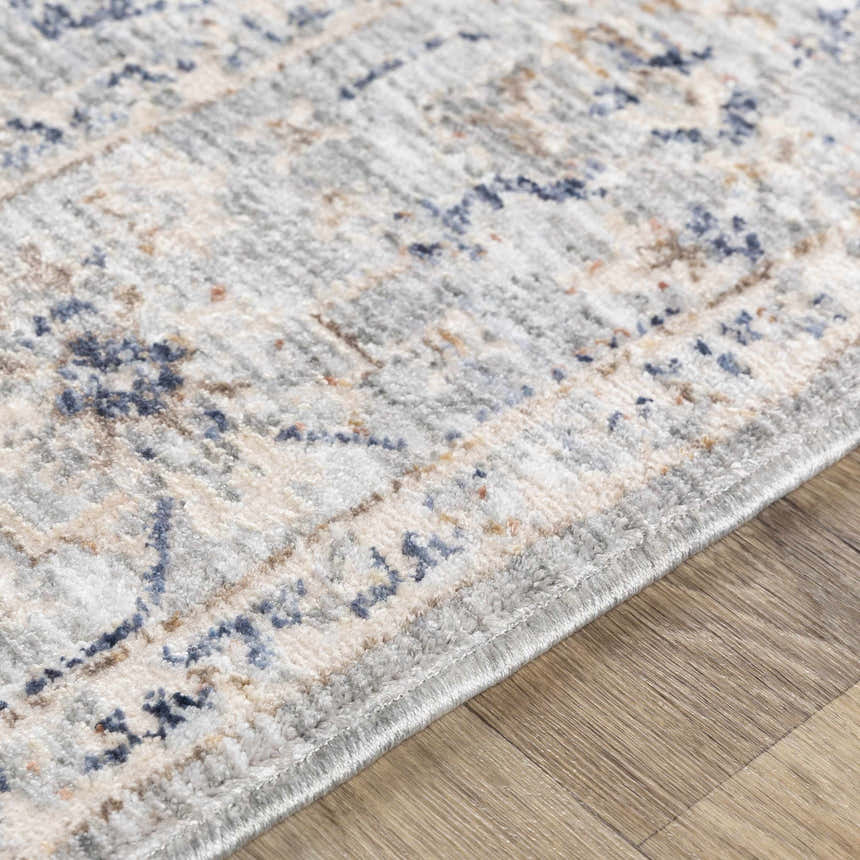 Close up of Brodhead Luxe Area Rug showing its traditional pattern, cream, brown, and navy colors, and soft texture. Texture