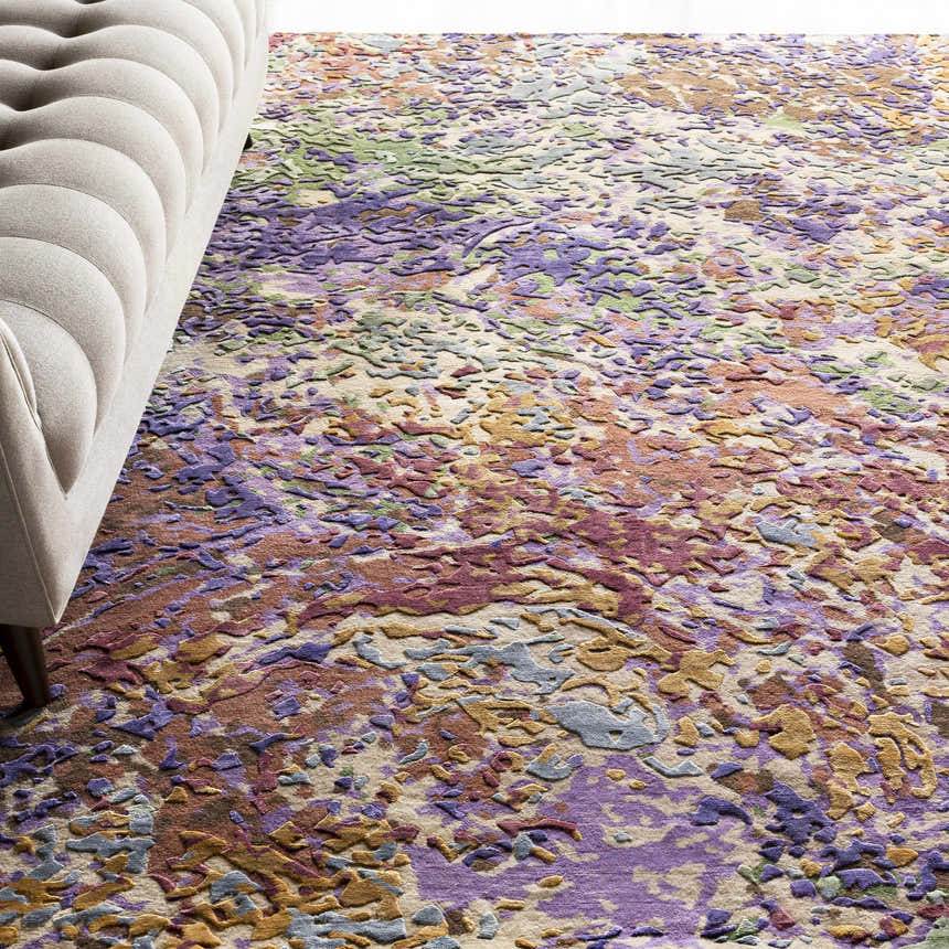 Contemporary living room with a tufted sofa and the Bronxville Area Rug in dark brown, lavender, lilac, olive, and peach. Styleshot
