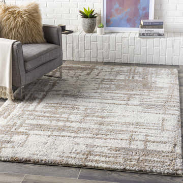 Living room scene with cream Broulee Abstract Striped Plush Rug, gray chair, and white brick fireplace. Roomscene-Rectangle