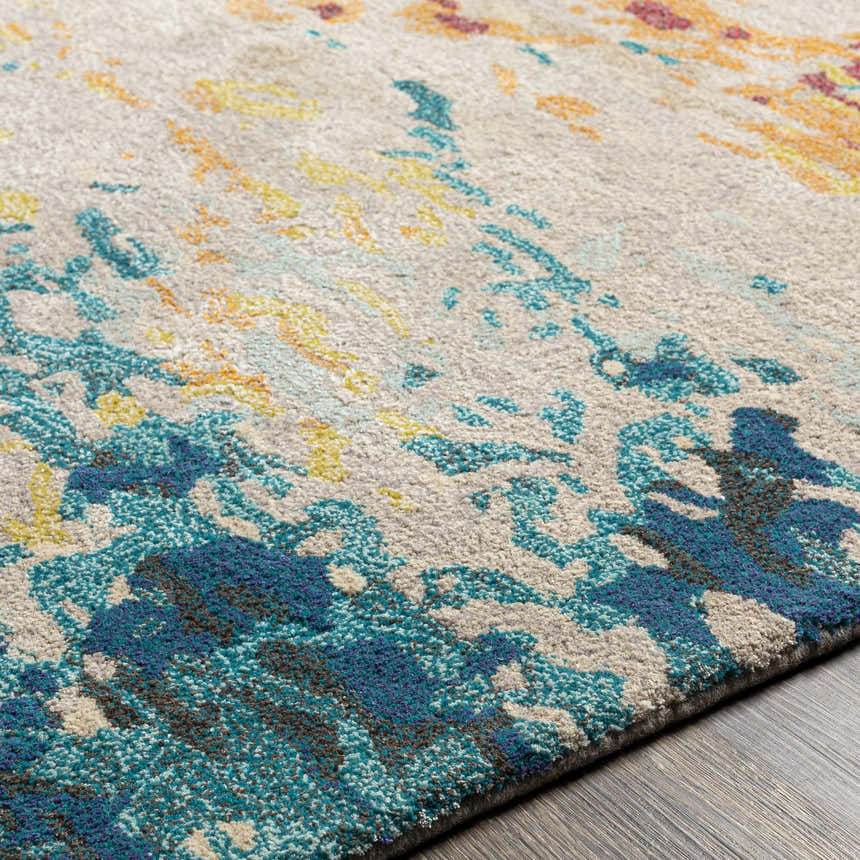 Close-up of Bualan Stone Pattern Wool Blend Rug showing aqua, yellow, and orange abstract design. Texture