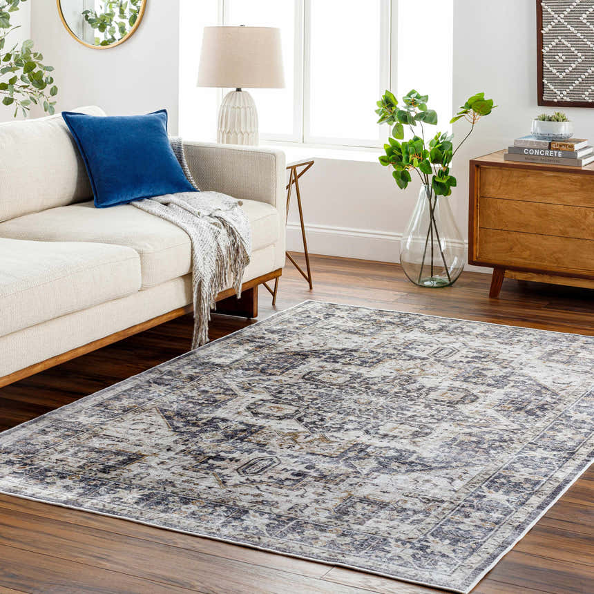 Living room scene with a neutral sofa and the gray and brown Bevin Washable Area Rug on a wood floor. Roomscene-Rectangle