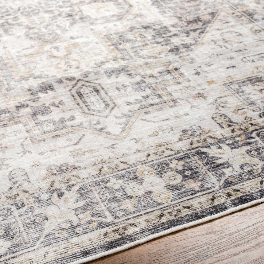Close-up of the Bevin Washable Area Rug, showcasing its traditional pattern, dark gray, taupe, and natural gray colors. Texture