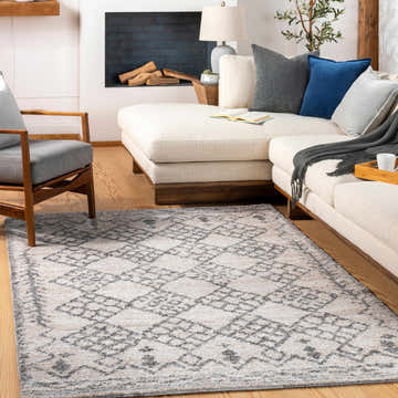 Living room with a beige sectional, gray chair, and the Bow Area Rug in gray and off-white. Roomscene-Rectangle