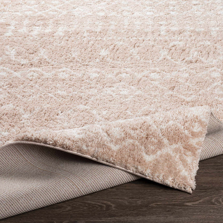 Close-up of the Blush Plush Area Rug showing its soft, textured pile and blush and cream colors. Fold