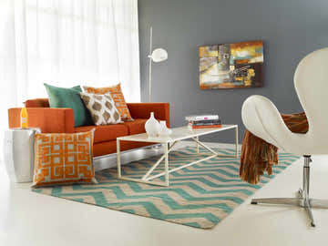 Living room with emerald and gray Calamus Area Rug, orange sofa, white coffee table, and modern decor. Roomscene-Rectangle