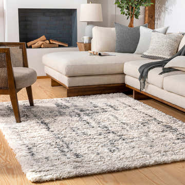 Living room scene with a cream sectional sofa and Campion Plush Cream Rug with black and beige accents. Roomscene-Rectangle