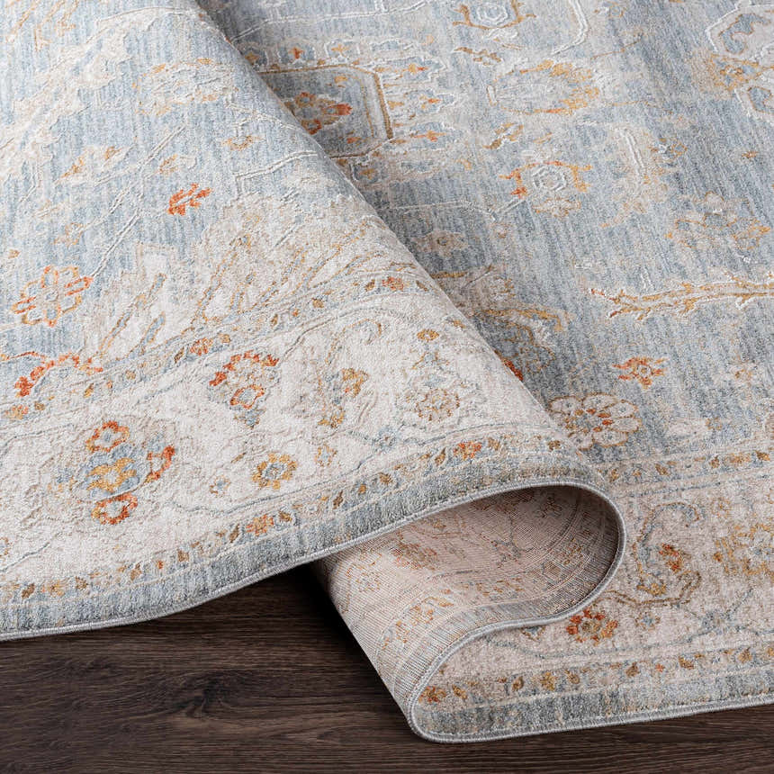 Close up of the Camrose rug in light beige, light gray, brick red, and mustard. Traditional oriental rug pattern. Fold