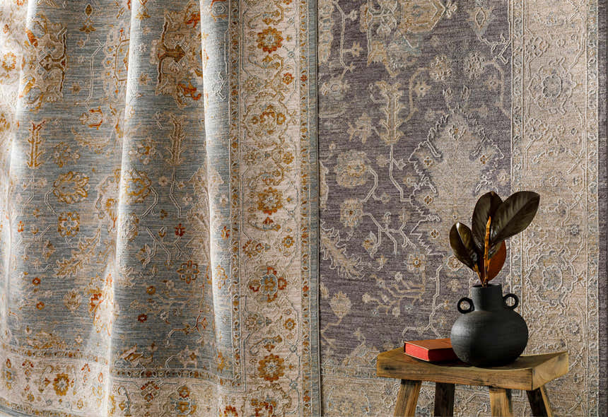 Close-up of Camrose Thick Luxe Statement Rug in brick red, charcoal, and light beige with a traditional floral pattern. Styleshot