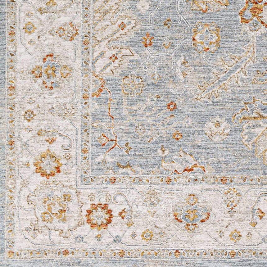 Close-up of the Camrose Thick Luxe Statement Rug. Features a traditional floral pattern in light blue, beige, and orange. Swatch
