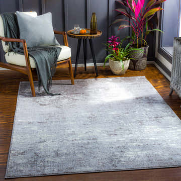 Living room scene with a gray and cream Canhandugan Area Rug, wood chair, and side table. Roomscene-Rectangle