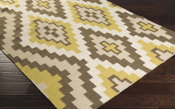 Close-up of the hand woven Caspiana Area Rug. Cream, light beige, olive, and brown geometric pattern. 100% wool rug. Corner