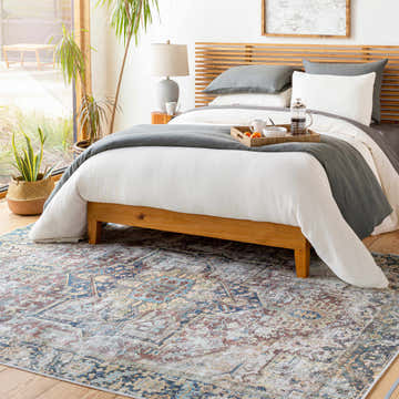 Bedroom scene with the Blue Catigpian Distressed Washable Area Rug. Farmhouse style with wood bed frame and gray bedding. Roomscene-Rectangle