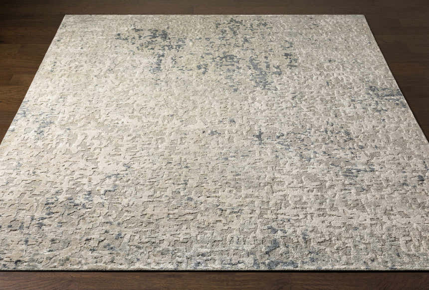 Close-up of the Cayuga Area Rug: a contemporary, hand-knotted silk rug in off-white with dark blue, sage, and slate accents. Front