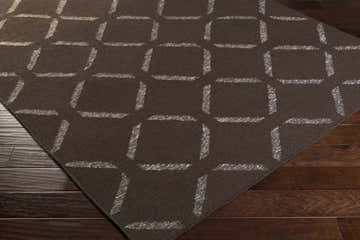 Close-up of the Charty Hand Woven Area Carpet, a dark brown wool rug with an off-white geometric square pattern. Corner