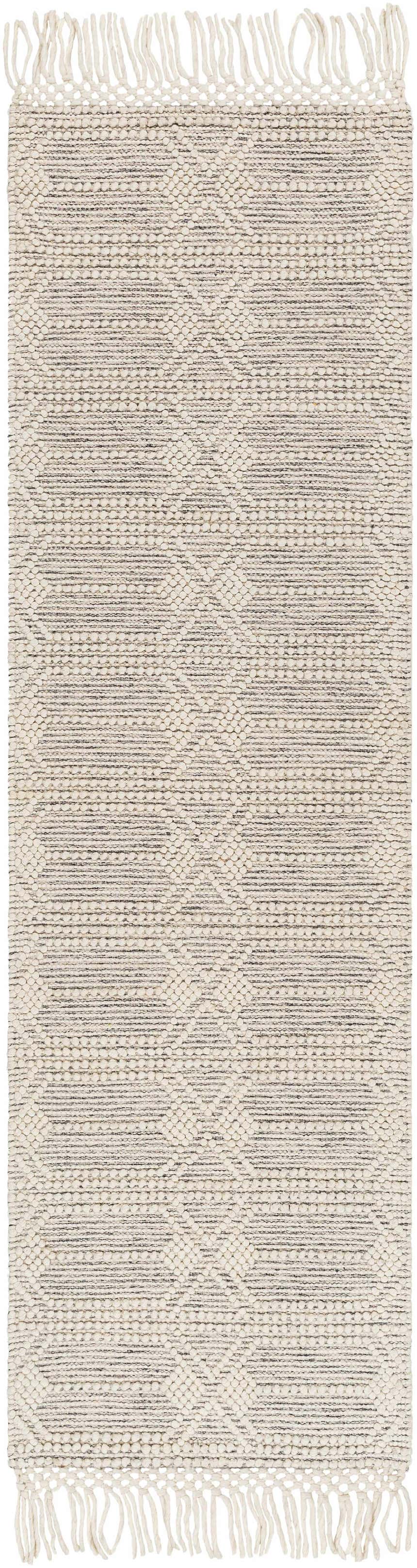 Close-up of the Chars Wool Rug with Tassels. Bone and gray geometric pattern with fringe detail. Hand woven texture. Design-Runner-2376