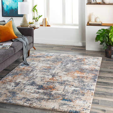 Living room scene with gray sofa and Chetwynd Abstract Thick Rug in blue, brown, cream, and coral tones. Roomscene-Rectangle