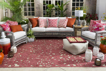 Outdoor patio scene with wicker furniture and a red floral Chinchilla Area Carpet. Roomscene-Rectangle